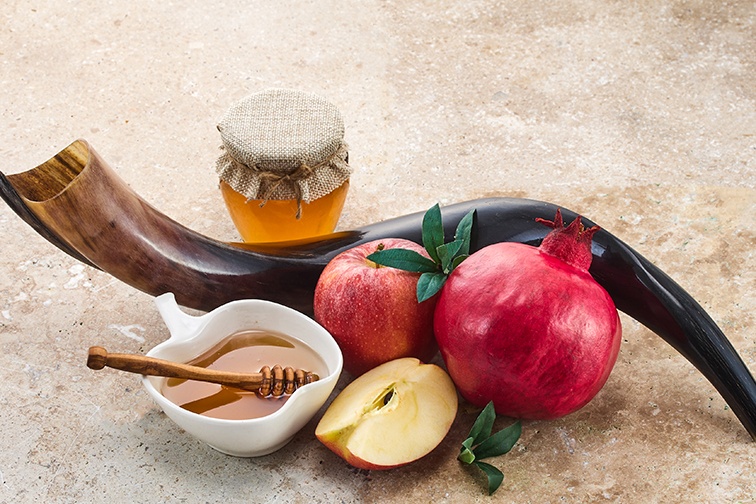 Rosh Hashana table with shofar, honey, apple and pomegranate